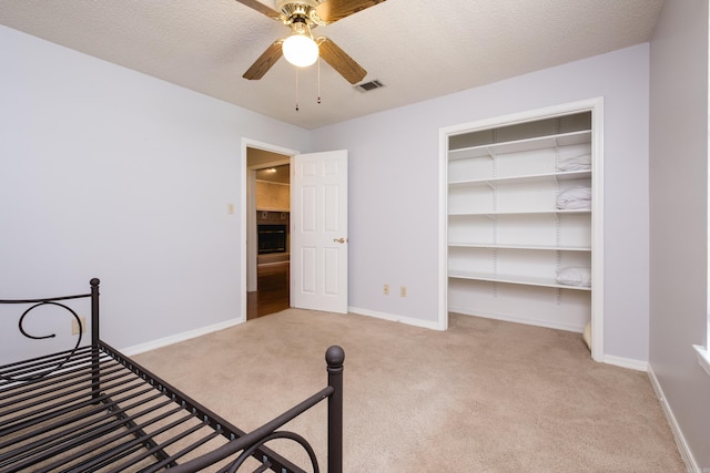 unfurnished bedroom featuring carpet flooring, baseboards, visible vents, and ceiling fan