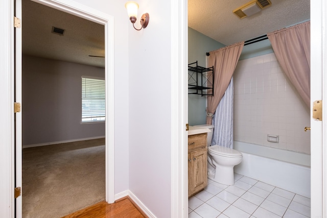 full bathroom featuring visible vents, vanity, shower / bath combination with curtain, toilet, and a textured ceiling