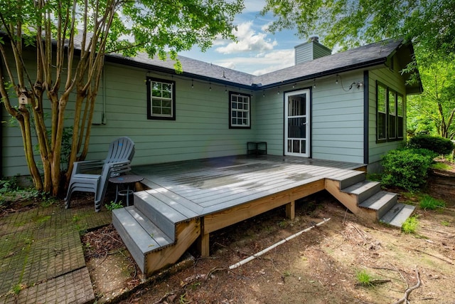 rear view of house with a chimney and a deck