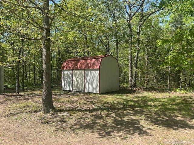 view of shed featuring a view of trees