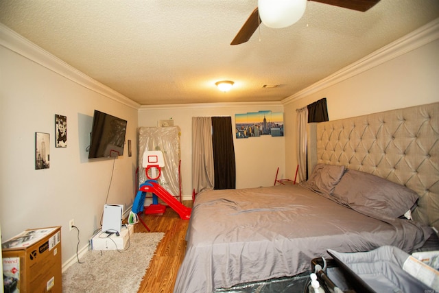bedroom featuring crown molding, a ceiling fan, a textured ceiling, and wood finished floors