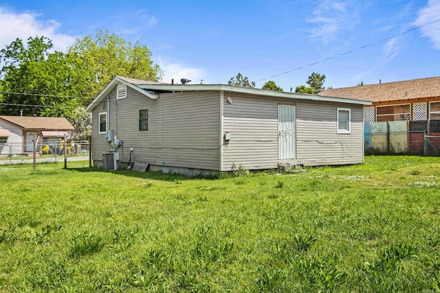 rear view of property with a lawn, fence, crawl space, and cooling unit
