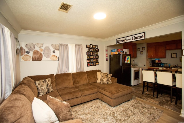 living area featuring ornamental molding, dark wood-style floors, a textured ceiling, and visible vents