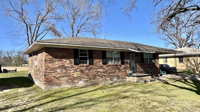 view of front facade featuring brick siding, a front lawn, and crawl space