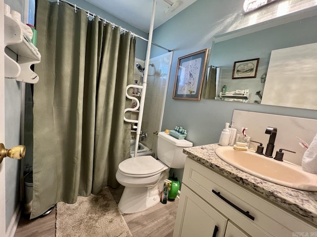 bathroom featuring toilet, shower / bath combination with curtain, wood finished floors, and vanity