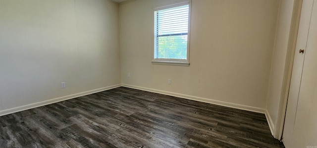 spare room featuring baseboards and dark wood-style flooring