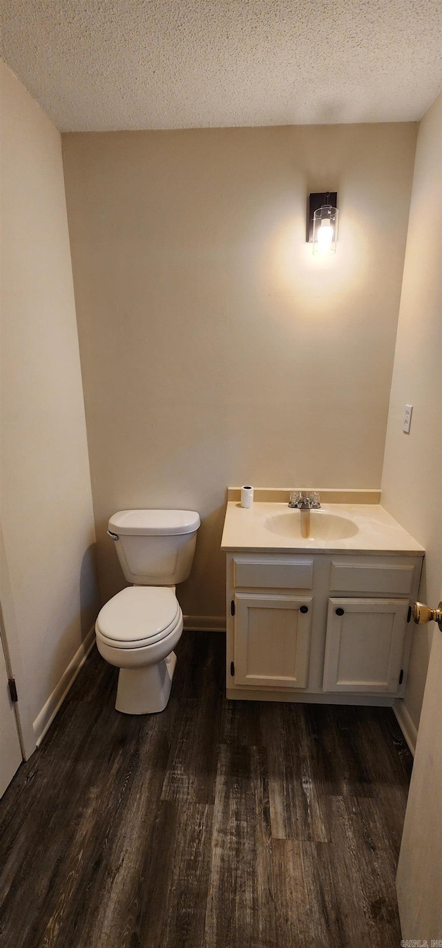 bathroom with vanity, a textured ceiling, toilet, and wood finished floors