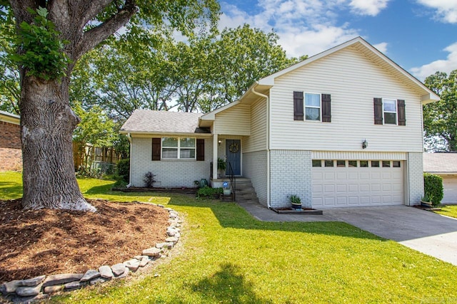 tri-level home with a garage, a front yard, driveway, and brick siding