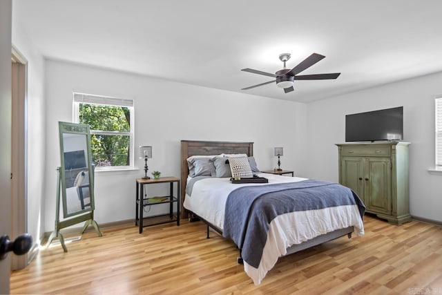 bedroom with light wood-style floors, baseboards, and a ceiling fan