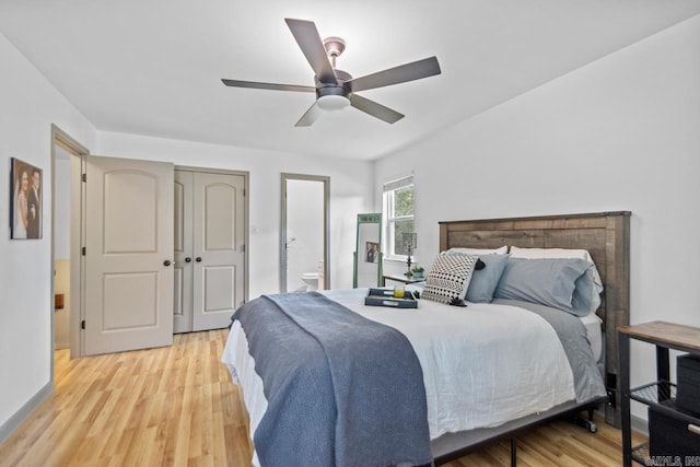 bedroom featuring light wood-style floors, ensuite bathroom, and a ceiling fan