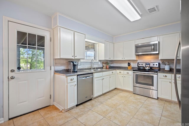 kitchen with a sink, backsplash, a healthy amount of sunlight, and stainless steel appliances