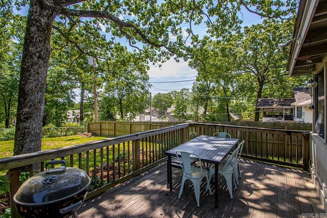 wooden terrace featuring a lawn, a fenced backyard, and outdoor dining space