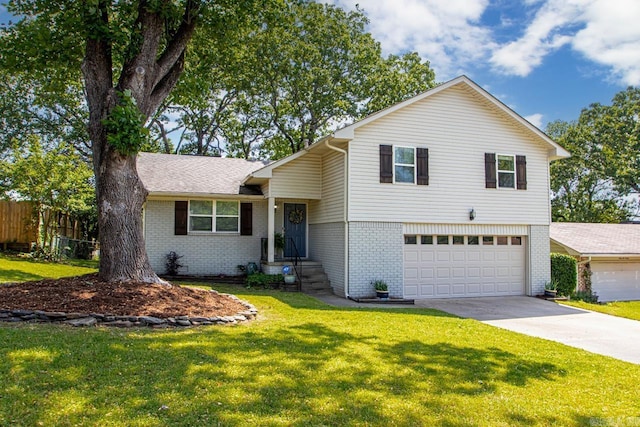 tri-level home with brick siding, an attached garage, fence, and concrete driveway