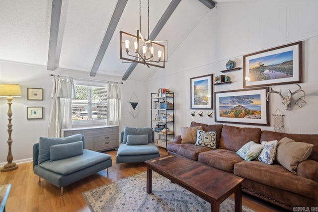 living area with a chandelier, vaulted ceiling with beams, and wood finished floors