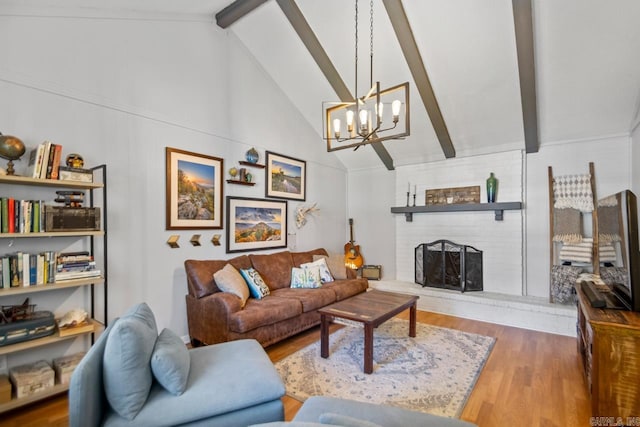 living area featuring a fireplace, lofted ceiling with beams, wood finished floors, and a notable chandelier