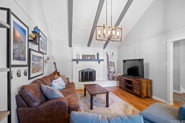 living area with a brick fireplace, beam ceiling, wood finished floors, high vaulted ceiling, and a notable chandelier