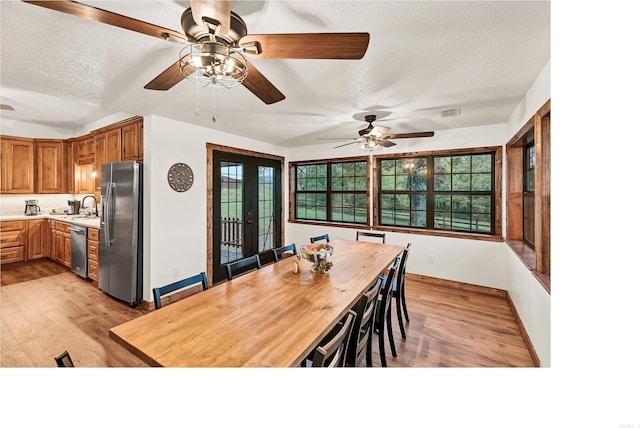 190 Polk Road 624, Mena, AR 71953 - dining area with visible vents, baseboards, a textured ceiling, a ceiling fan, and light wood-style flooring