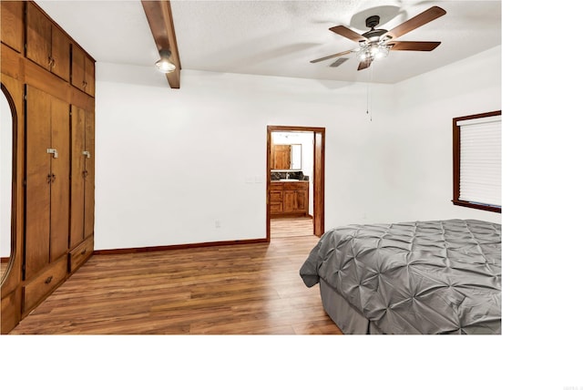 190 Polk Road 624, Mena, AR 71953 - bedroom featuring a ceiling fan, light wood-type flooring, baseboards, beamed ceiling, and ensuite bath