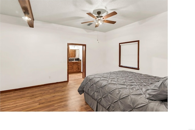 190 Polk Road 624, Mena, AR 71953 - bedroom featuring a ceiling fan, beam ceiling, wood finished floors, baseboards, and ensuite bathroom