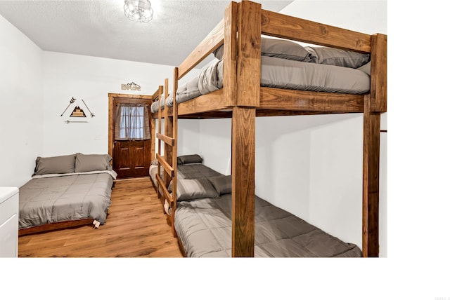 190 Polk Road 624, Mena, AR 71953 - bedroom featuring light wood-type flooring and a textured ceiling