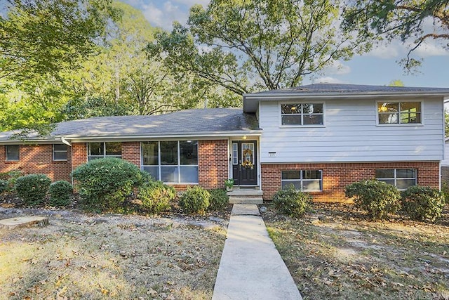 tri-level home featuring brick siding