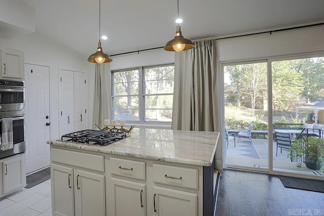 kitchen with stainless steel double oven, pendant lighting, light stone counters, white cabinets, and black gas stovetop