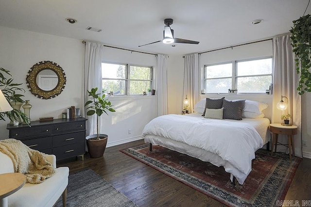 bedroom featuring a ceiling fan, baseboards, visible vents, and wood finished floors