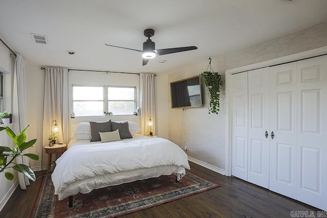 bedroom featuring baseboards, visible vents, dark wood finished floors, and a closet