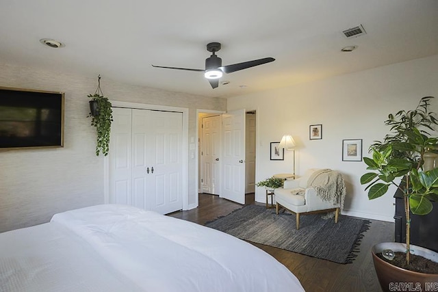 bedroom featuring a ceiling fan, visible vents, wood finished floors, baseboards, and a closet