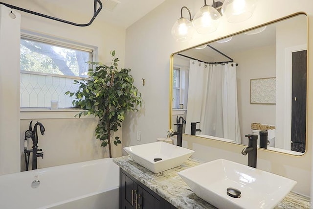 full bathroom featuring a sink, visible vents, and a freestanding bath