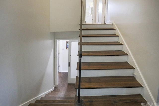 stairs featuring baseboards and wood finished floors
