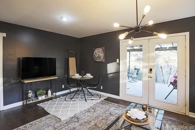 living room featuring an inviting chandelier, baseboards, wood finished floors, and french doors