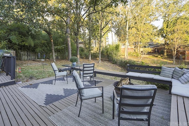 wooden deck with outdoor dining area, a fenced backyard, and an outdoor living space