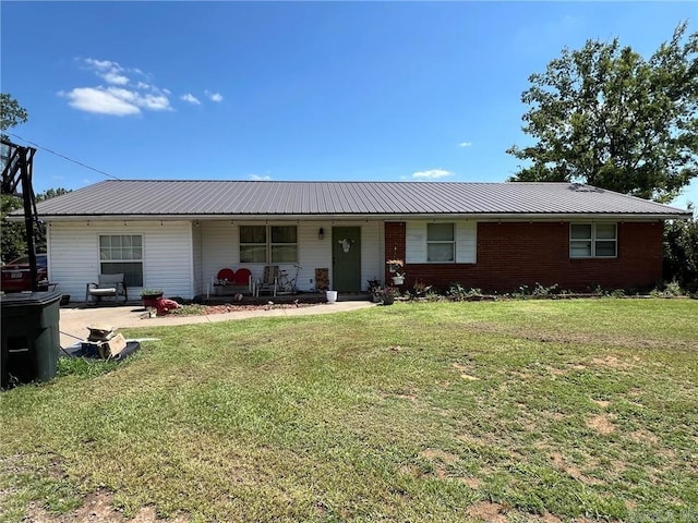 ranch-style house featuring covered porch, metal roof, and a front yard