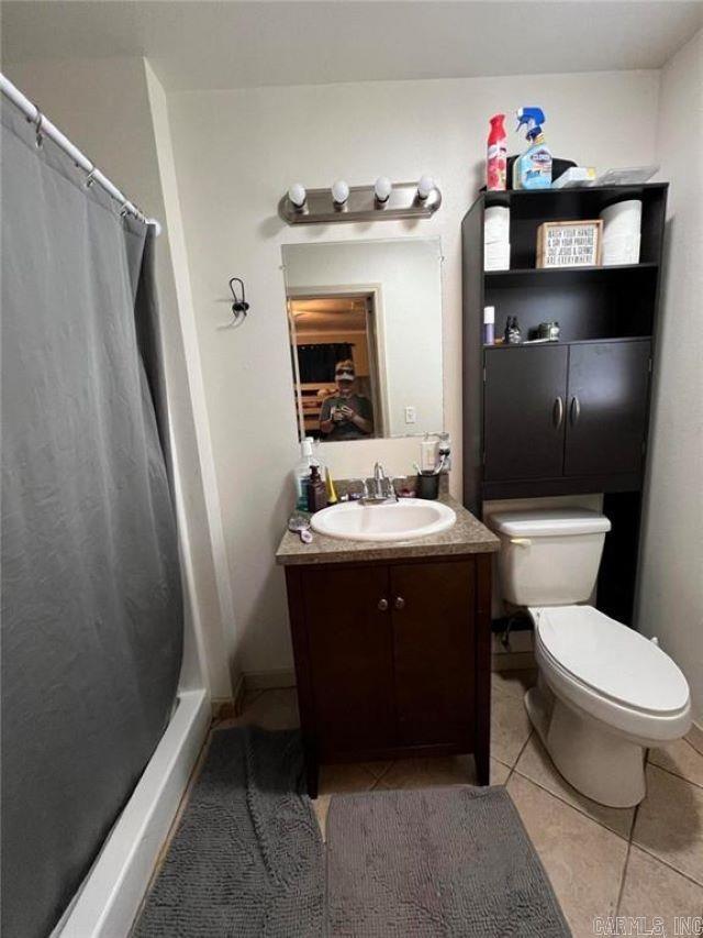 bathroom featuring toilet, tile patterned floors, a shower with curtain, and vanity