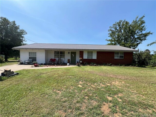 single story home featuring metal roof, a porch, and a front lawn
