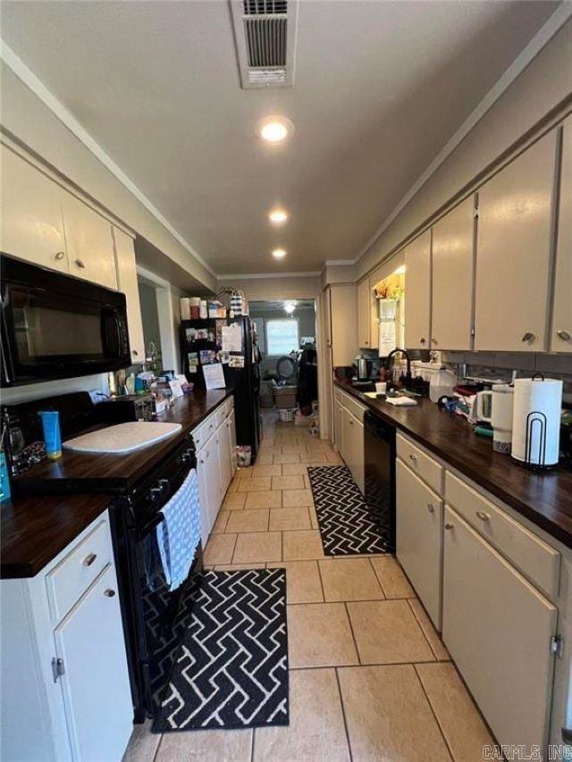 kitchen with crown molding, a sink, white cabinetry, visible vents, and black appliances