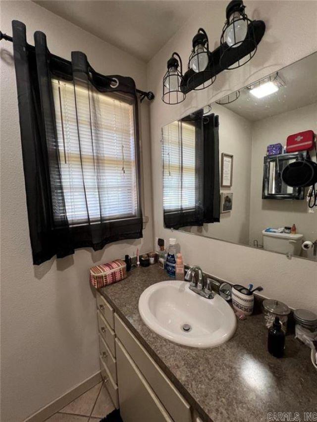 bathroom featuring vanity, tile patterned flooring, and baseboards