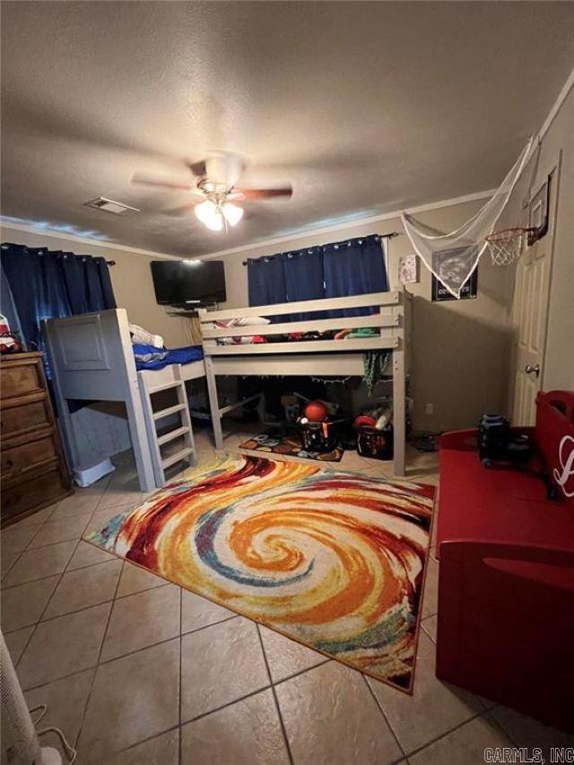 tiled bedroom featuring ceiling fan and visible vents
