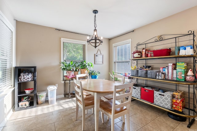 dining area featuring tile patterned floors and a chandelier