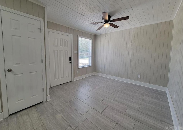 entrance foyer featuring wood walls, baseboards, ceiling fan, wood finish floors, and wooden ceiling