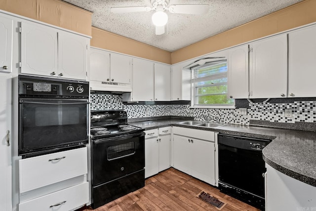 kitchen featuring a sink, dark countertops, black appliances, and under cabinet range hood