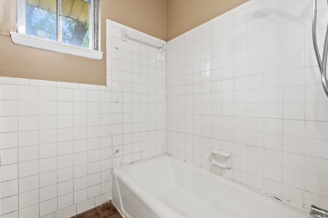 bathroom featuring tile walls and a tub to relax in