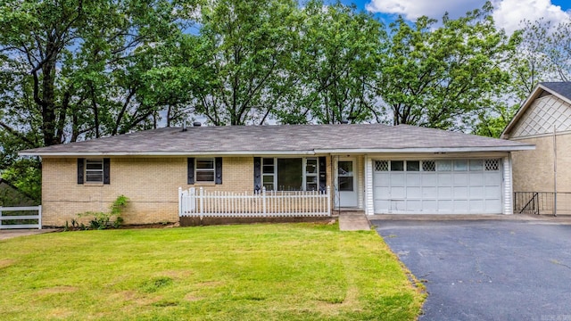 single story home featuring fence, brick siding, a garage, aphalt driveway, and a front yard