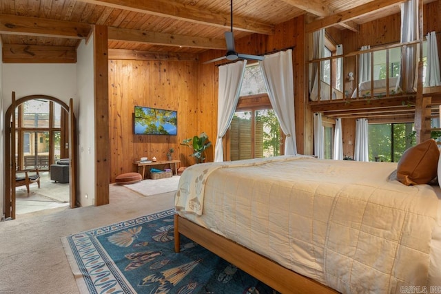 bedroom with carpet floors, beam ceiling, wooden walls, and wooden ceiling