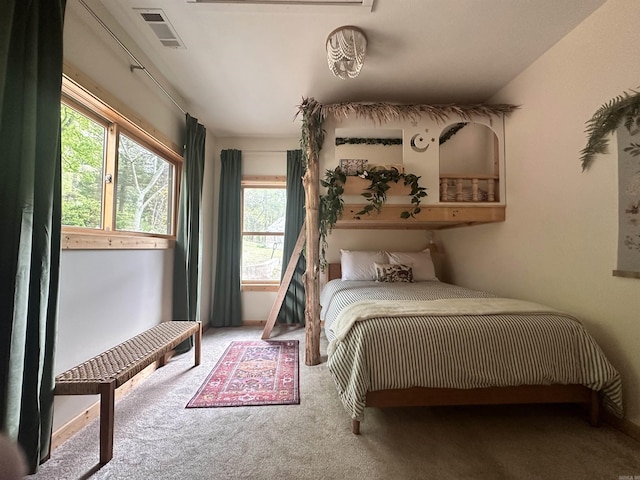 carpeted bedroom with visible vents and multiple windows