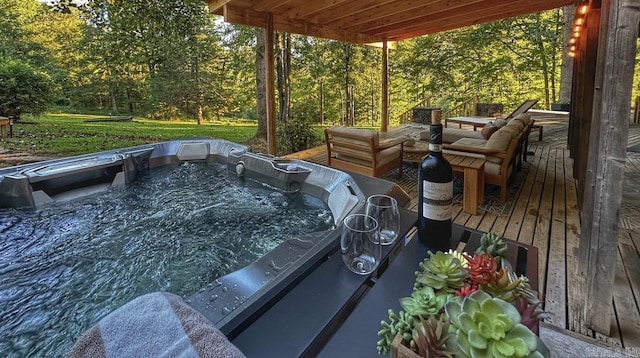wooden terrace featuring a hot tub and a forest view