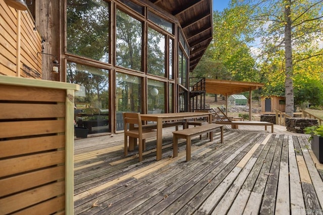 wooden terrace featuring an outbuilding and a shed