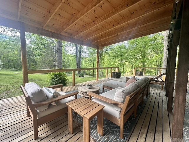 sunroom featuring a healthy amount of sunlight, an outdoor hangout area, and beam ceiling