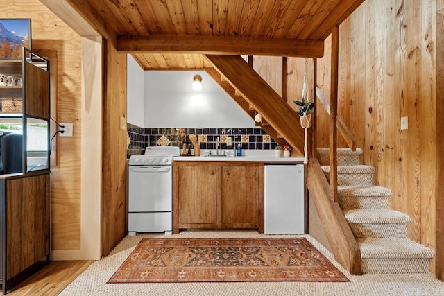 bar featuring wood walls, refrigerator, white range with electric cooktop, and stairway